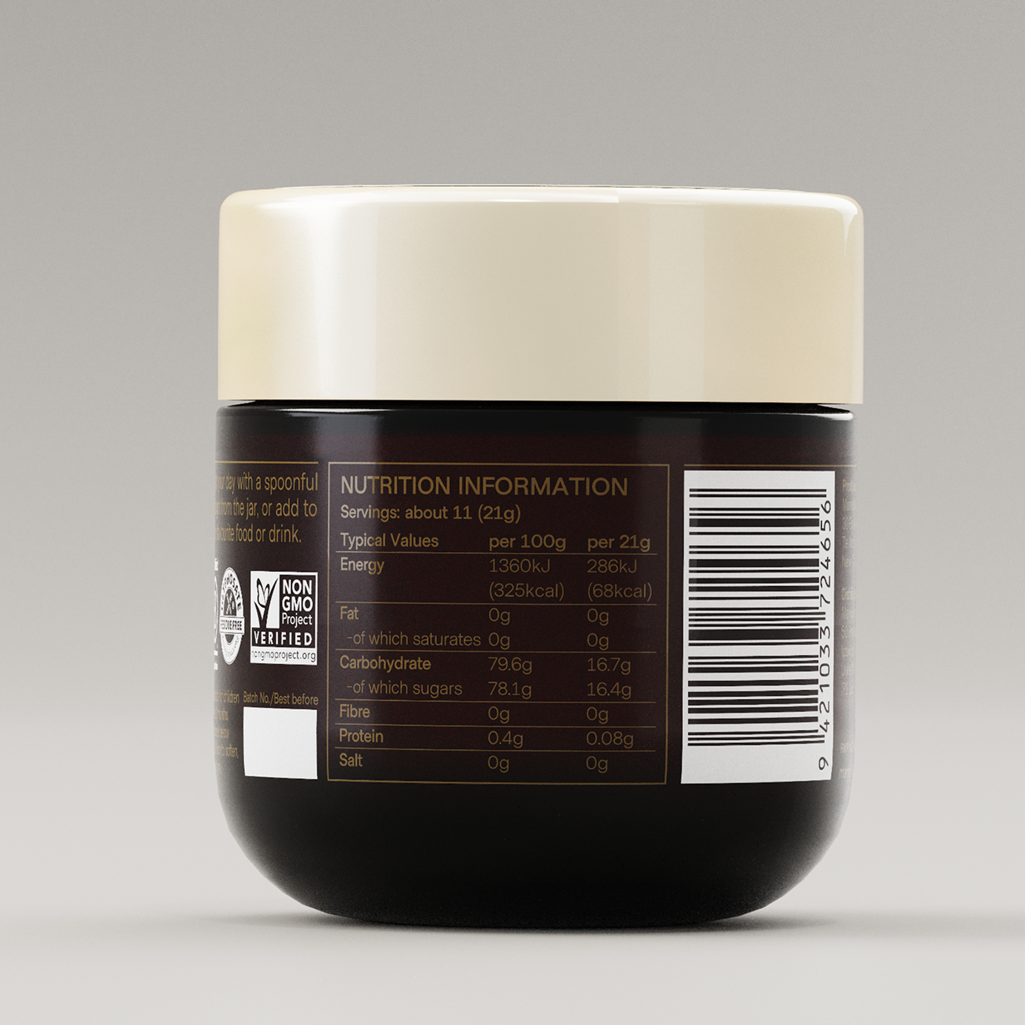 A hand holding a spoonful of Manukora raw Mānuka honey.